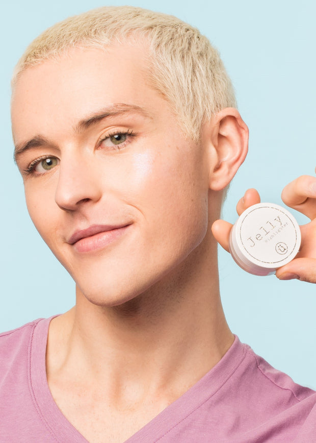 man holding the vegan, cruelty free jelly highlighter with a soft smile