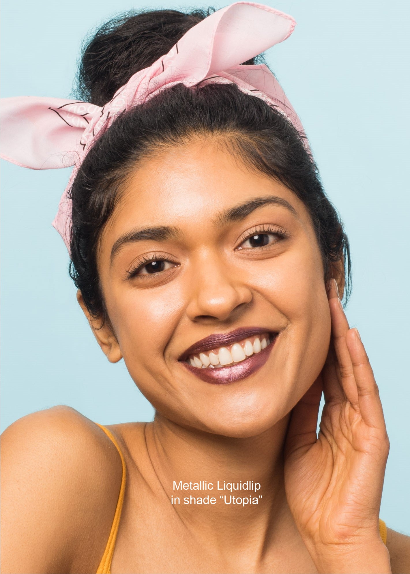 girl wearing metallic liquid lip smiling with her left hand on the face