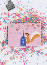 empire state building inspired eyeshadow palette sitting among colorful sprinkles and a mini empire state building 
