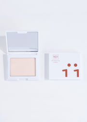 two perfecting powder compacts in shade light, one open and one closed
