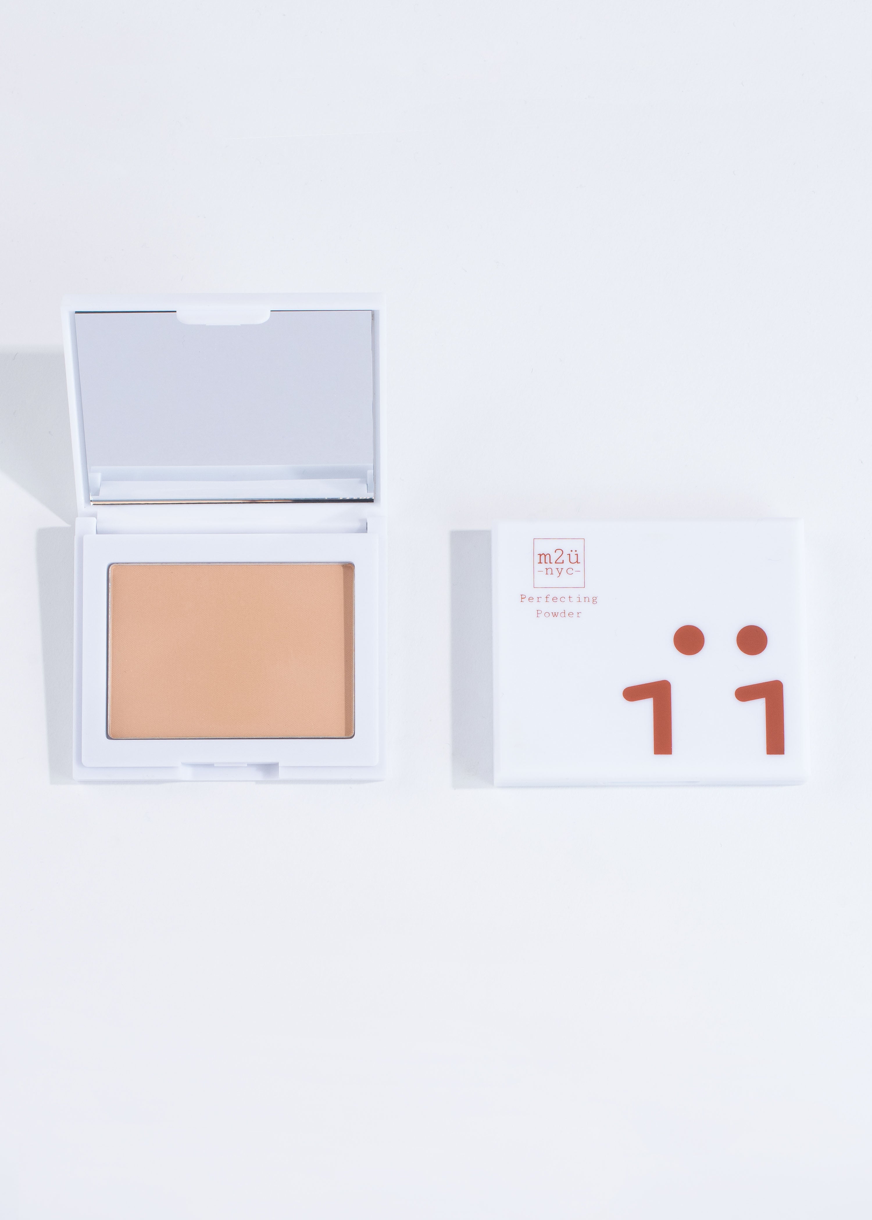 two perfecting powder compacts in shade medium, one open and one closed