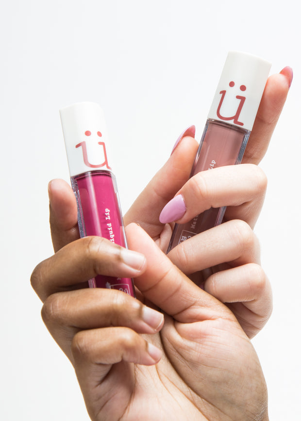 two hands holding matte liquid lipsticks in shades spring and cherry st respectively 