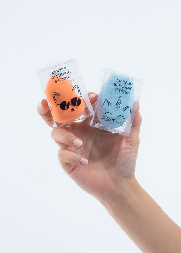 hand holding two makeup blending sponges, one orange and one blue